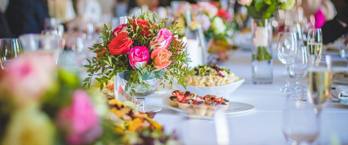 Festlich gedeckte Tafel mit Blumenschmuck, Gläsern und Vorspeisen